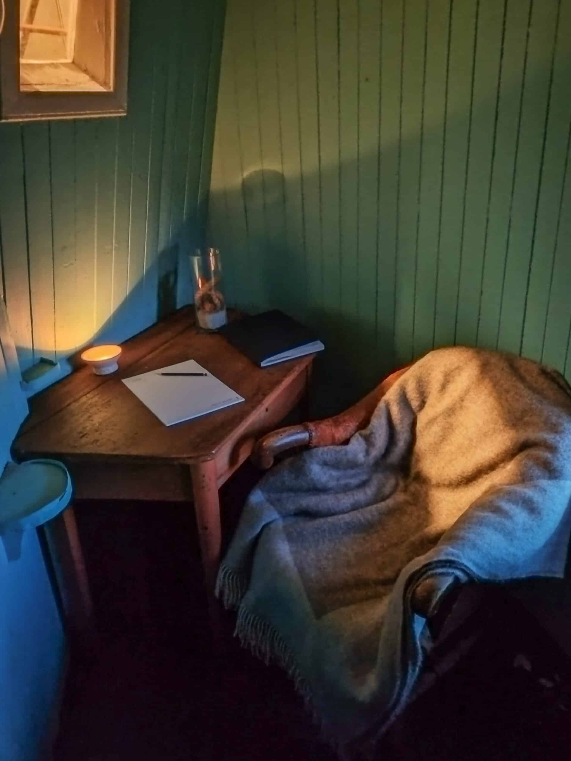 Lite møterom inne i Ona Fyr, med stemningsfull belysning og varme farger.