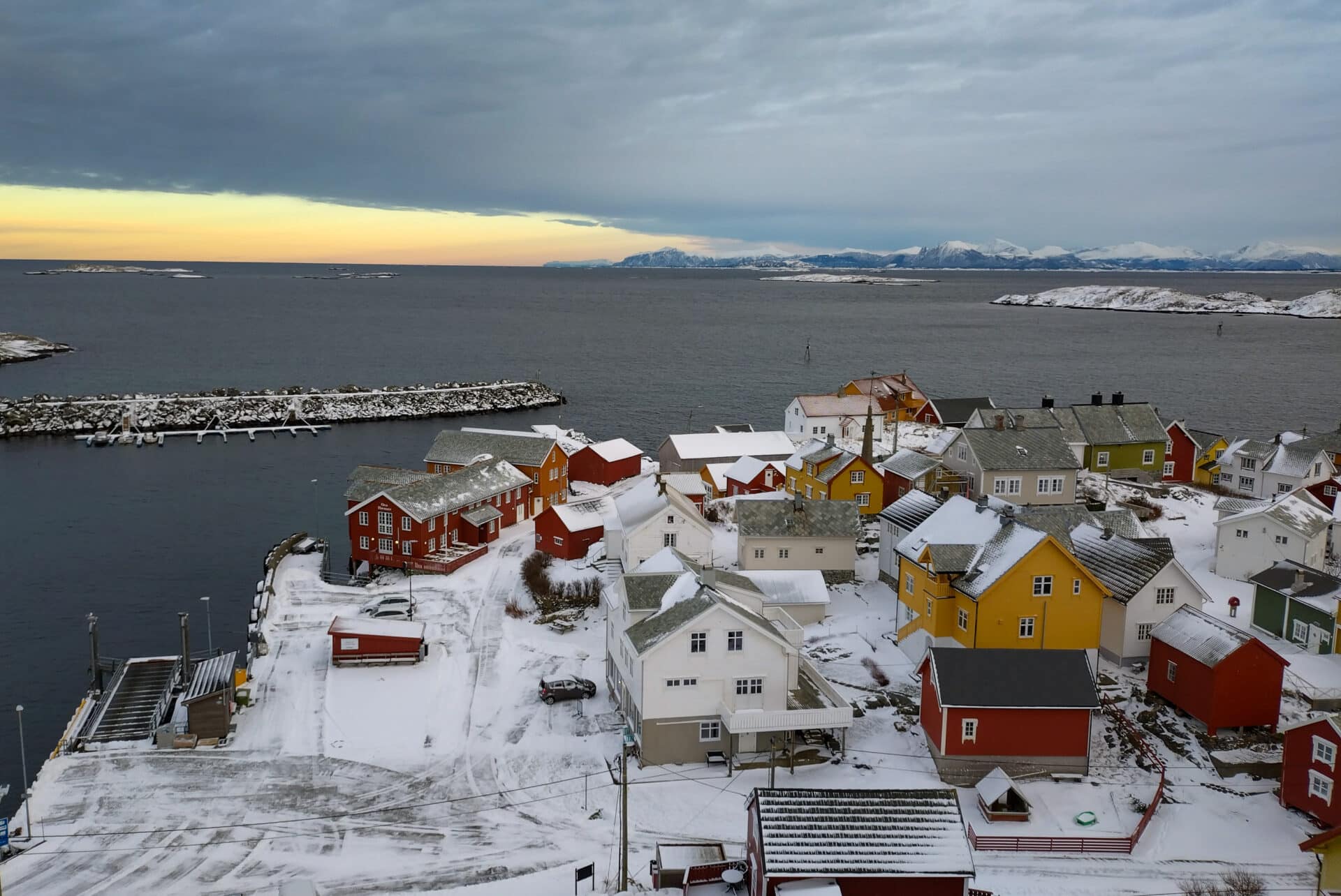 Snødekte sommerhus på Ona Havstuer, vinter og magisk lys over havet.