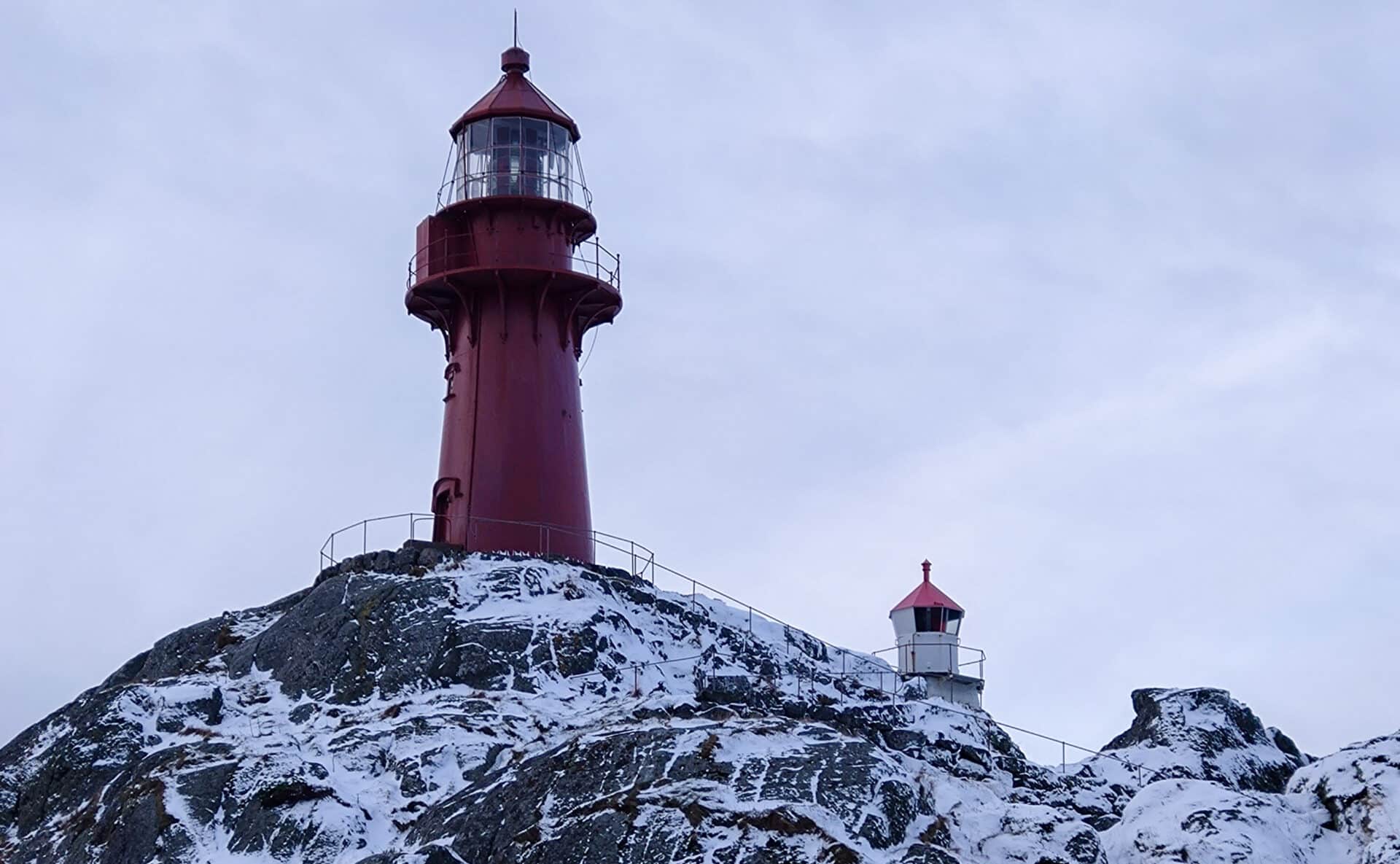 Ona Fyr med snø, omgitt av vinterlys og vakker natur.